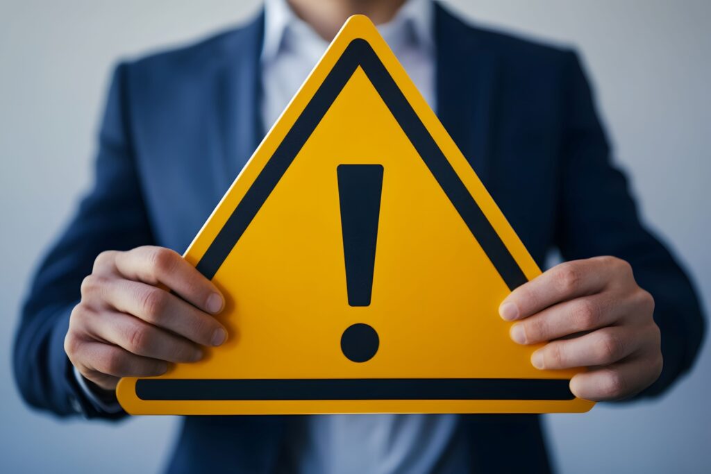 注意マークを持つスーツ姿の男性のコンセプト写真